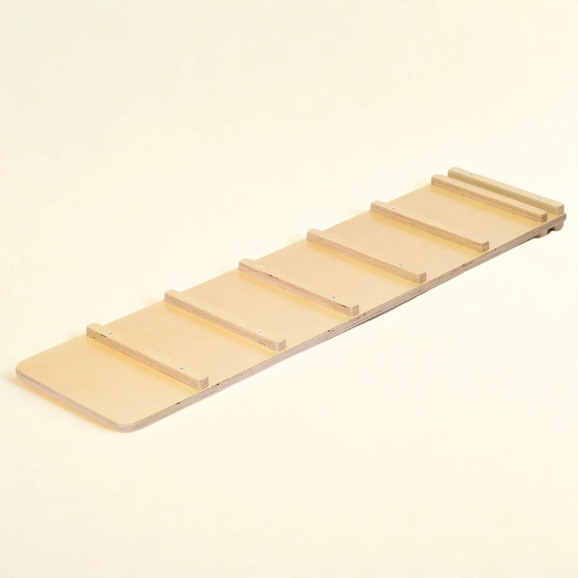 Wooden sensory ramp for kids, natural finish, with six raised rails on a cream background
