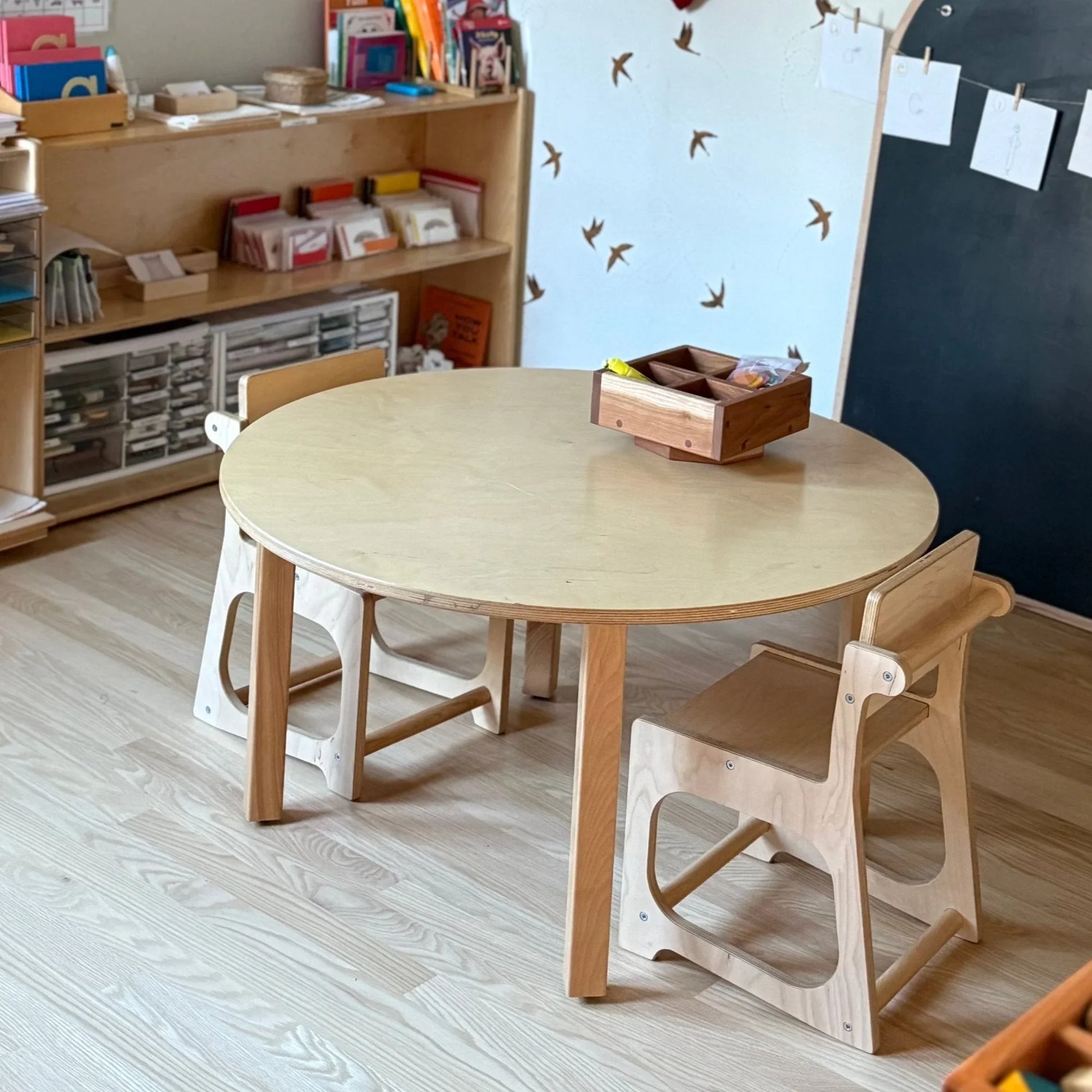 Kids round wooden sensory table and chairs in an organized learning space
