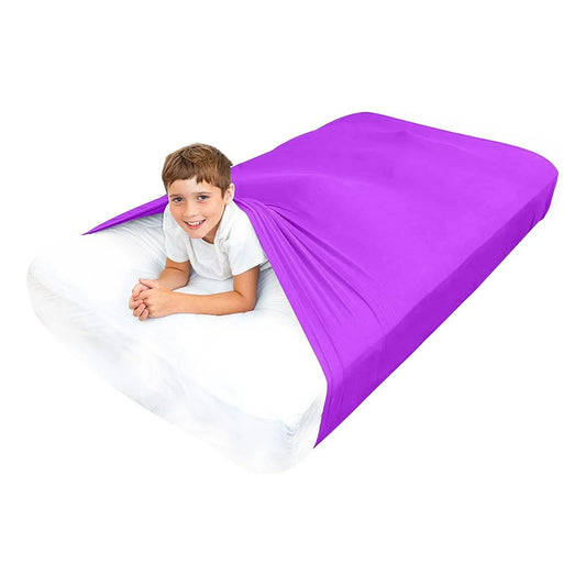 Child in white shirt under purple sensory compression sheet on a bed, sensory sleep aid