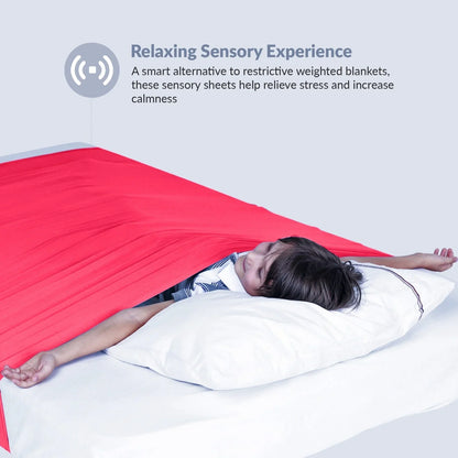 Child lying under a red sensory compression sheet for stress relief and calm sleep support