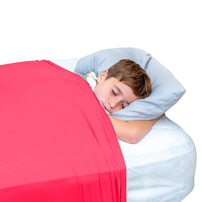 Child sleeping under a red sensory compression sheet on a bed with a light blue pillow