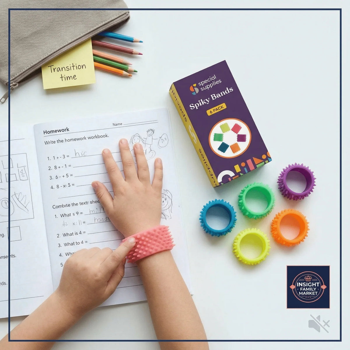 Child wearing spiky band while doing homework, with colorful fidget bands nearby.