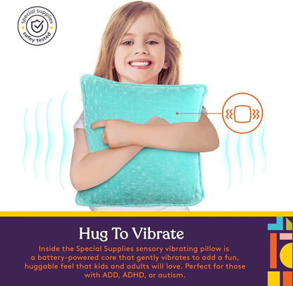 Smiling child hugging a blue sensory vibrating pillow designed for sensory support and comfort