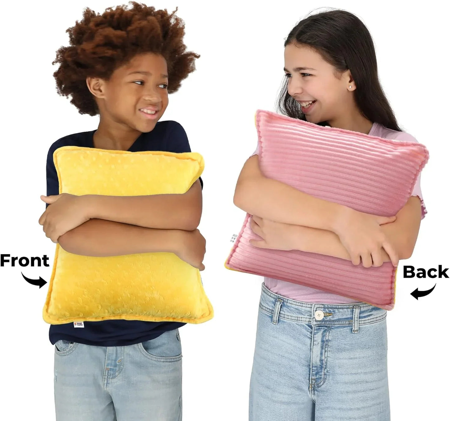 Two kids hugging a reversible sensory pillow, yellow on front and pink on back