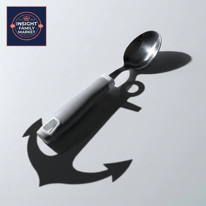 Adaptive spoon with ergonomic gray handle casting anchor-shaped shadow on white surface