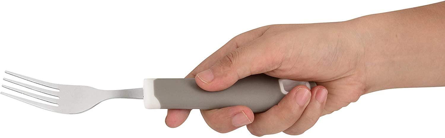 Hand holding a gray ergonomic adaptive fork with non-slip handle