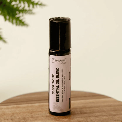 Sleep Tight crystal-infused essential oil blend roller bottle for sleep support on wood table