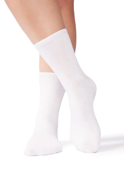 Person wearing soft white sensory-friendly crew socks on a white background