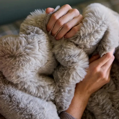 Hands holding a soft, plush grey sensory blanket, ideal for calming comfort