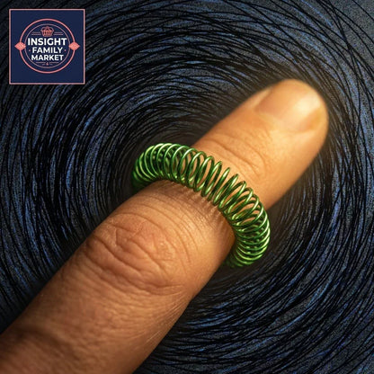 Finger wearing a green sensory fidget ring against a textured dark background