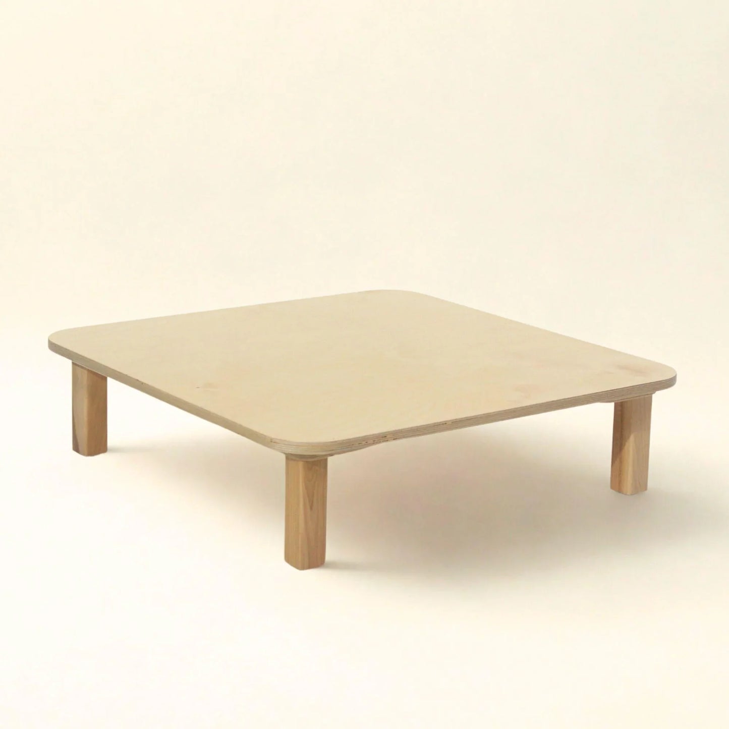 Minimalist square wooden sensory-friendly table with rounded corners on a neutral background
