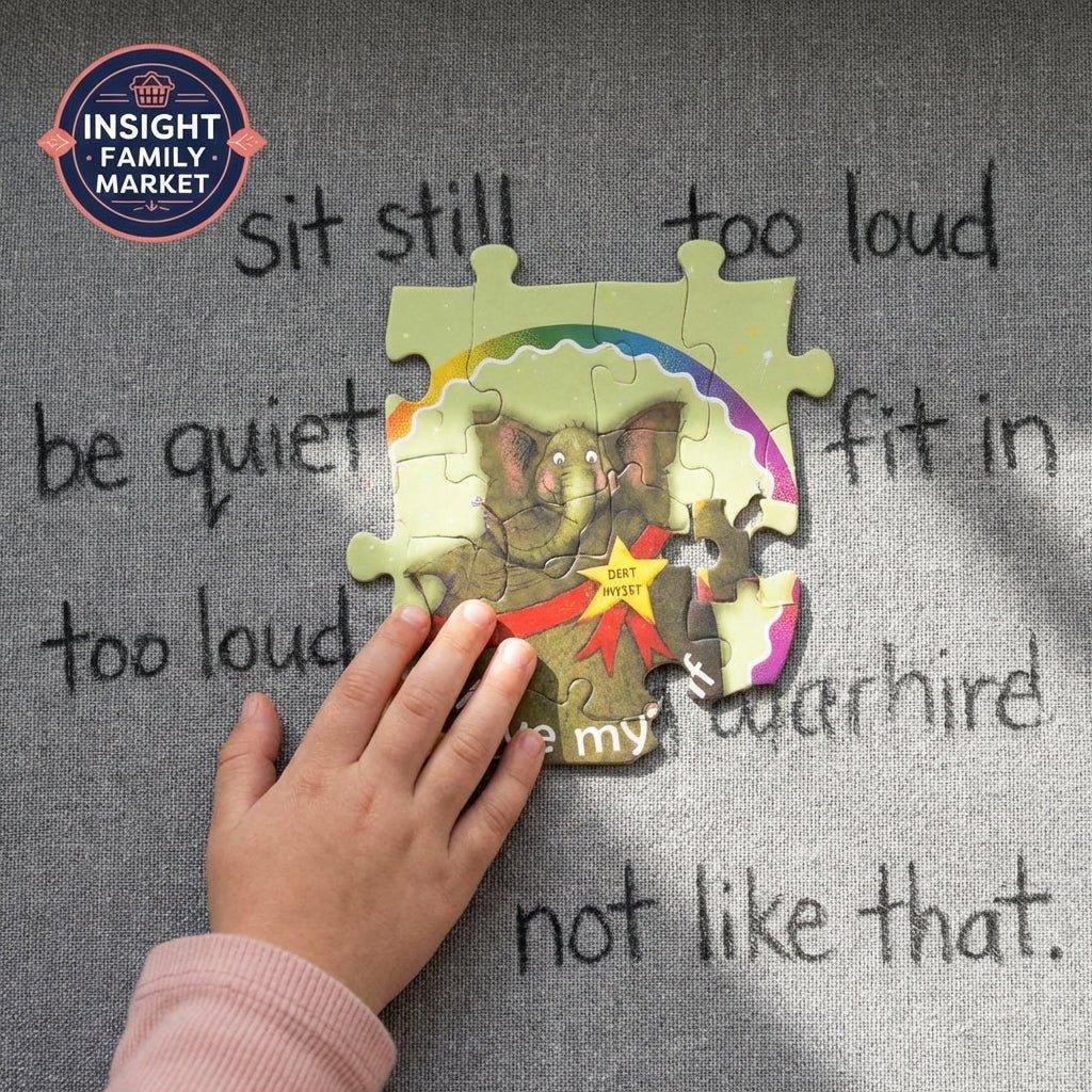 Child's hand assembling elephant puzzle over sensory-friendly message on grey fabric