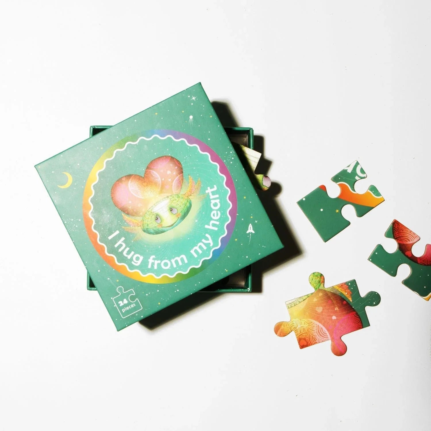 Colorful 24-piece sensory-friendly puzzle box with heart and creature, pieces scattered nearby