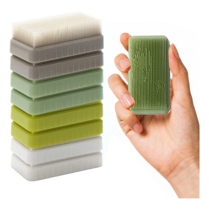 Hand holding a sensory tactile brush with a stack of textured stim sensory brushes.