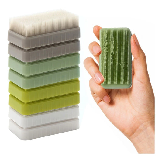 Hand holding a sensory tactile brush with a stack of textured stim sensory brushes.