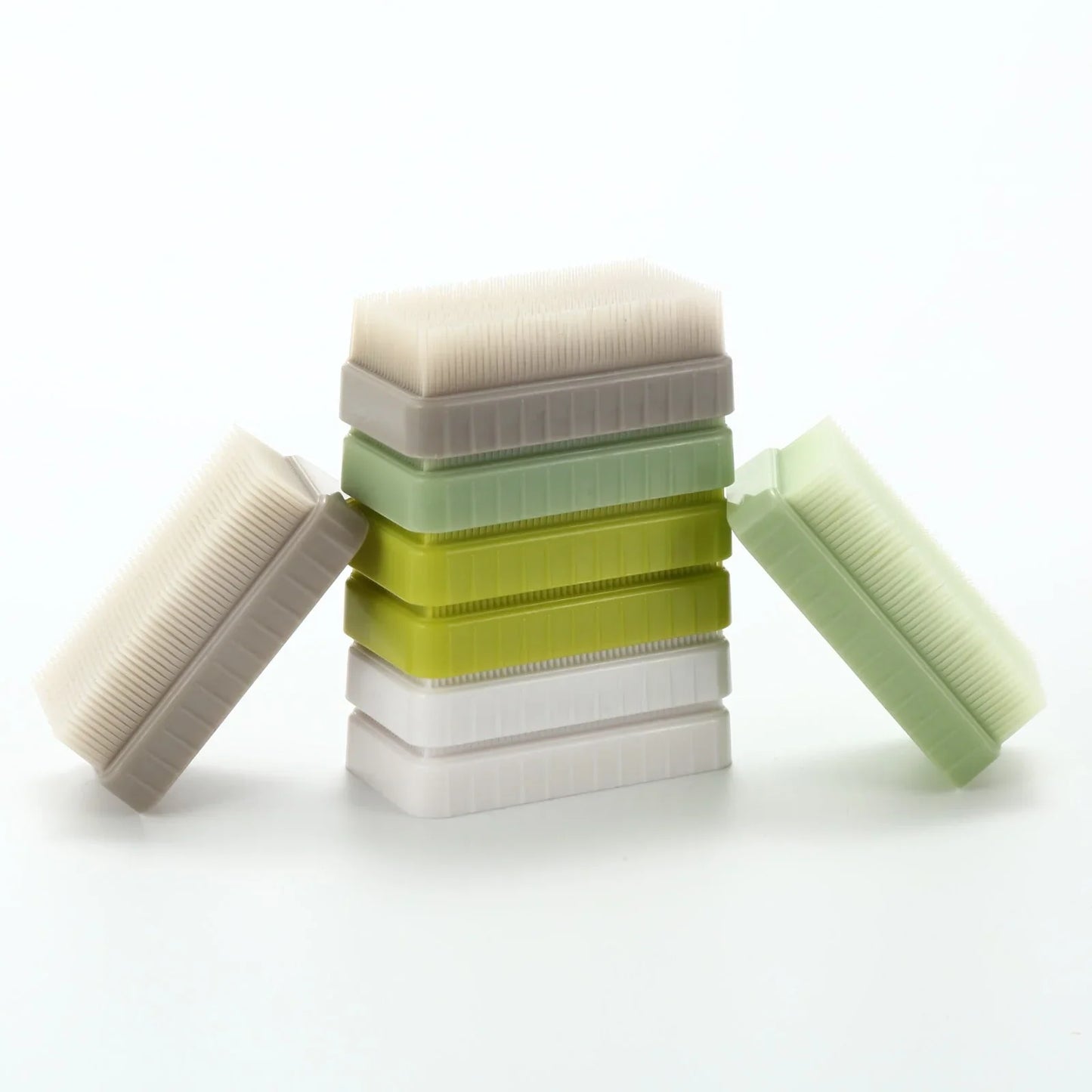 Stack of sensory brushes in white, green, and yellow for tactile sensory support