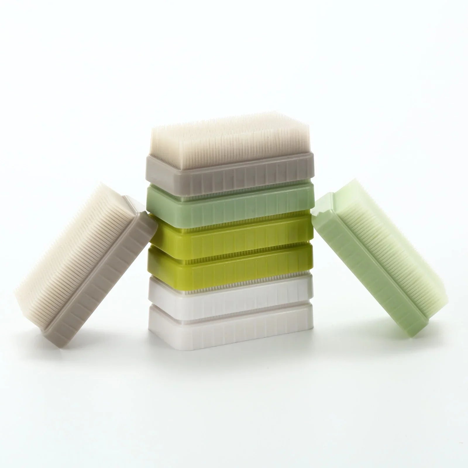 Stack of sensory brushes in white, green, and yellow for tactile sensory support