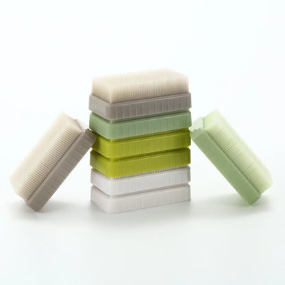 Stack of sensory brushes in white, green, and yellow for tactile sensory support
