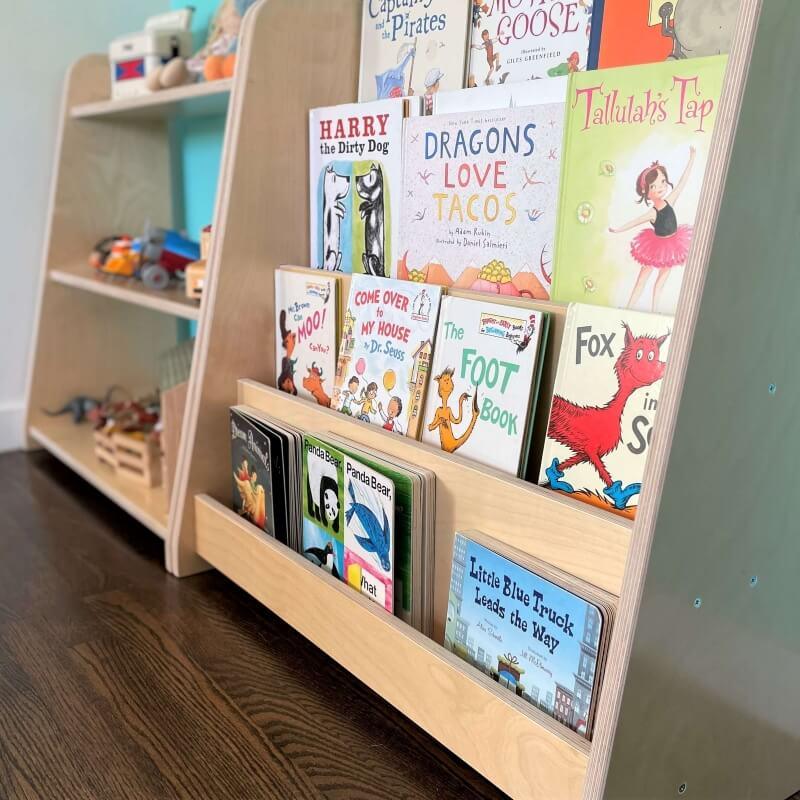 Montessori-style wooden bookshelf with children's books and sensory toys