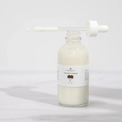 Glass bottle of True Belly Serum with dropper, creamy texture, minimalist background