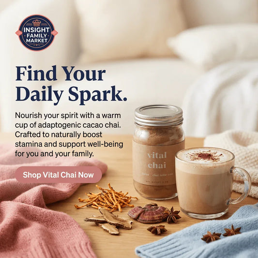 Glass mug of cacao chai latte and a jar labeled 'vital chai' on cozy table with adaptogenic herbs.