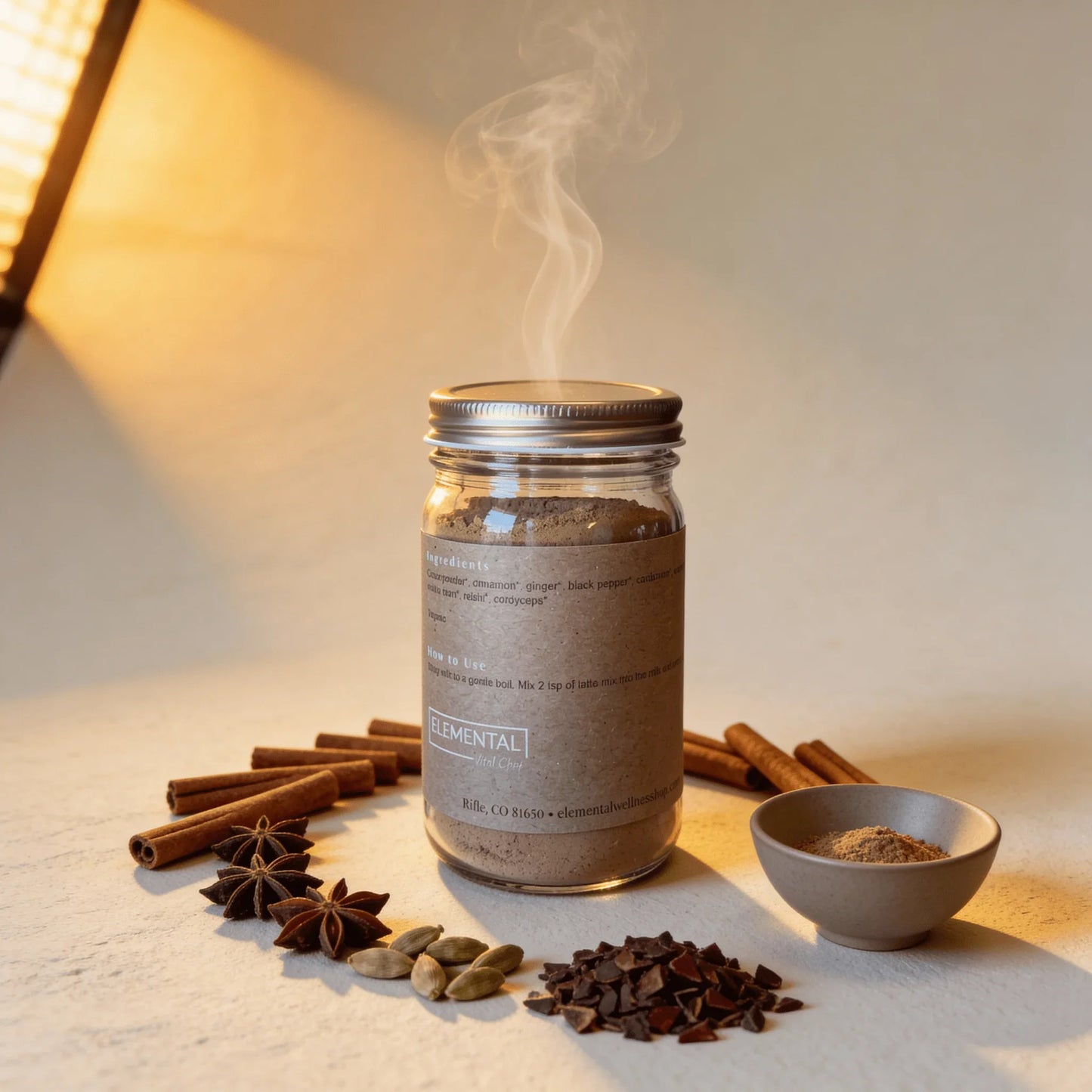 Glass jar of chai spice latte mix with cinnamon, star anise, cardamom, and bowl of powder.